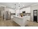 Bright white kitchen with stainless steel appliances, stone countertops and island with pendant lighting at 5750 Long Shore Loop, Sarasota, FL 34238