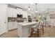 Modern white kitchen with stone countertops, stainless steel appliances, and breakfast bar seating at 5750 Long Shore Loop, Sarasota, FL 34238