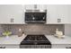A kitchen showcasing stainless steel appliances, white cabinets, granite countertops and tile backsplash at 5750 Long Shore Loop, Sarasota, FL 34238