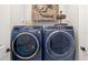Modern laundry room features front load washer and dryer with wooden decor at 5750 Long Shore Loop, Sarasota, FL 34238