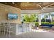 An outdoor bar and seating area with a large screen television for entertainment at 5750 Long Shore Loop, Sarasota, FL 34238