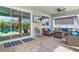 Covered patio with ceiling fan, sliding glass doors, tv and comfortable seating area. Perfect for entertaining at 5750 Long Shore Loop, Sarasota, FL 34238
