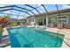 Large screened-in pool with in-pool seating, patio with furniture and grill, perfect for entertaining at 5750 Long Shore Loop, Sarasota, FL 34238