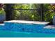 A close up of a pool with blue tile and a small waterfall feature at 5750 Long Shore Loop, Sarasota, FL 34238