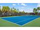Well-maintained tennis court with a secure net and privacy fencing at 5750 Long Shore Loop, Sarasota, FL 34238