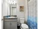 Bathroom with a granite vanity, a toilet, and blue and gray shower curtain at 5802 Alabaster Stone Ln, Apollo Beach, FL 33572