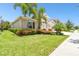 Charming single-story home with well-manicured lawn, tropical landscaping, and attached two-car garage at 5802 Alabaster Stone Ln, Apollo Beach, FL 33572