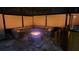 Outdoor screened-in fire pit with lights and stonework benches creating a cozy atmosphere at 5802 Alabaster Stone Ln, Apollo Beach, FL 33572