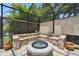 Outdoor screened-in fire pit featuring stonework benches, ideal for gatherings at 5802 Alabaster Stone Ln, Apollo Beach, FL 33572