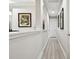 Bright hallway with wood-look floors and decorative wall art leading to other rooms at 5802 Alabaster Stone Ln, Apollo Beach, FL 33572