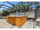 Screened-in hot tub featuring a bar top and seating for relaxation at 5802 Alabaster Stone Ln, Apollo Beach, FL 33572