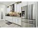Kitchen with stainless steel refrigerator, white cabinets, and a modern tile backsplash at 5802 Alabaster Stone Ln, Apollo Beach, FL 33572