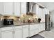 Modern kitchen featuring stainless steel appliances, tile backsplash, and white cabinetry at 5802 Alabaster Stone Ln, Apollo Beach, FL 33572