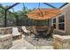 Outdoor screened-in patio includes an umbrella, stone columns and patio seating at 5802 Alabaster Stone Ln, Apollo Beach, FL 33572