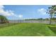 Green backyard with a partial lake view, complimented by black aluminum fencing and lush lawn at 5910 Hevena Ct, Palmetto, FL 34221
