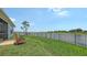 Well-manicured backyard with a view of the water, black metal fence, and patio at 5910 Hevena Ct, Palmetto, FL 34221