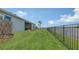 Expansive backyard with water view, black metal fence, patio, and lush green grass at 5910 Hevena Ct, Palmetto, FL 34221