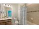 Well-lit bathroom with neutral tones and coastal decor elements with a shower tub combo at 5910 Hevena Ct, Palmetto, FL 34221