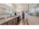 Elegant bathroom with double vanity sinks, granite countertops, and a walk-in closet at 5910 Hevena Ct, Palmetto, FL 34221