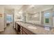 Bright bathroom features double vanity with granite counters and a glass enclosed walk-in shower at 5910 Hevena Ct, Palmetto, FL 34221