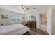 Comfortable bedroom with a ceiling fan, wood-look floors, a large window, and an adjacent sitting area at 5910 Hevena Ct, Palmetto, FL 34221