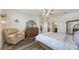 Bright bedroom featuring hardwood floors, ceiling fan, a sitting chair, and views to the en suite at 5910 Hevena Ct, Palmetto, FL 34221