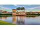 Elegant community entrance with stone accents, lush landscaping, and tranquil water views at 5910 Hevena Ct, Palmetto, FL 34221