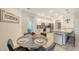 Dining area with a modern table and chairs is adjacent to the kitchen with bar stool seating at 5910 Hevena Ct, Palmetto, FL 34221