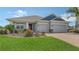 Charming single-Gathering home featuring well-manicured landscaping, a two-car garage, and a vibrant red door at 5910 Hevena Ct, Palmetto, FL 34221