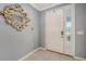 Inviting foyer features gray walls, tile flooring, a front door with sidelight, and a decorative mirror at 5910 Hevena Ct, Palmetto, FL 34221