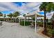 Outdoor lounge area with cabanas, tables, and chairs, set against a backdrop of lush landscaping and lake views at 5910 Hevena Ct, Palmetto, FL 34221