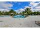 Expansive community swimming pool surrounded by palm trees and lounge chairs on a sunny day at 5910 Hevena Ct, Palmetto, FL 34221