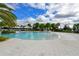 Community swimming pool with shallow entry, surrounded by lounge areas and palm trees at 5910 Hevena Ct, Palmetto, FL 34221
