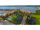 Scenic aerial shot of waterfront condos with tennis court, lush landscaping, marina, and stunning views at 610 Riviera Dunes Way # 306, Palmetto, FL 34221