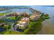 Aerial view of waterfront condo community showcasing marina access, lush greenery, and beautiful waterfront residences at 610 Riviera Dunes Way # 306, Palmetto, FL 34221