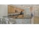 Well-equipped kitchen featuring granite countertops, wood cabinets, and a stylish tile backsplash at 610 Riviera Dunes Way # 306, Palmetto, FL 34221