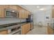 Well-lit kitchen with granite counters, stainless steel appliances, tile flooring, and a dining area at 610 Riviera Dunes Way # 306, Palmetto, FL 34221