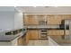 Modern kitchen featuring granite countertops, stainless steel appliances, and light wood cabinetry at 610 Riviera Dunes Way # 306, Palmetto, FL 34221