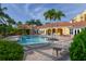 Community pool area with lounge chairs and palm trees providing a relaxing oasis for residents and their guests at 610 Riviera Dunes Way # 306, Palmetto, FL 34221