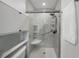 Walk-in shower featuring updated tile, sliding glass door, hand rails and shower seat at 627 Avenida Del Norte, Sarasota, FL 34242