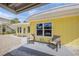Exterior view of a yellow home, showcasing the outdoor seating area and shell ground cover at 627 Avenida Del Norte, Sarasota, FL 34242