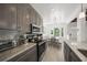 Bright kitchen features gray cabinets, granite countertops, modern appliances, and a cozy dining area at 627 Avenida Del Norte, Sarasota, FL 34242