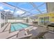 Screened-in pool area with lounge chairs, dining table and outdoor grill at 627 Avenida Del Norte, Sarasota, FL 34242