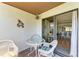 Covered balcony with tropical decor offers seamless indoor-outdoor living through sliding glass doors at 6840 Midnight Pass Rd # 6840, Sarasota, FL 34242