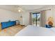 Bedroom with balcony access, pool view, wood floors, and ceiling fan at 6840 Midnight Pass Rd # 6840, Sarasota, FL 34242