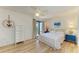 Bright bedroom with a queen bed, light wood floors, and sliding doors to the balcony at 6840 Midnight Pass Rd # 6840, Sarasota, FL 34242