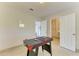 The bonus room with ping pong table transitions to doorways to laundry and front door at 6840 Midnight Pass Rd # 6840, Sarasota, FL 34242