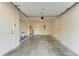 An empty garage with a concrete floor and a white door to interior of the home at 6840 Midnight Pass Rd # 6840, Sarasota, FL 34242