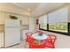 Eat-in kitchen nook offers white table with red chairs and bright window at 6840 Midnight Pass Rd # 6840, Sarasota, FL 34242