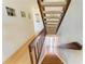Staircase with wooden railing and white walls, leading to the upper or lower floors, enhanced by decorative wall art at 6840 Midnight Pass Rd # 6840, Sarasota, FL 34242